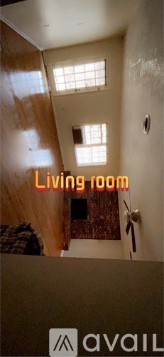 A living room with a window and a fan.