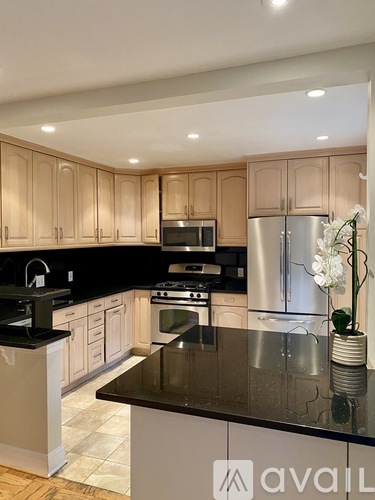 A kitchen with wooden cabinets and a black countertop.