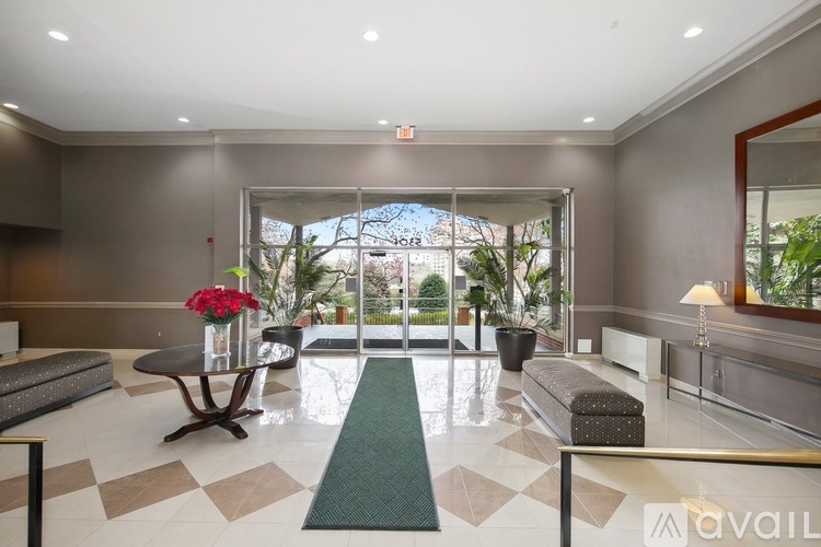 A spacious lobby with a green carpet and a glass wall.