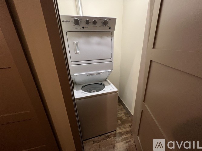 A stacked washer and dryer in a small room.