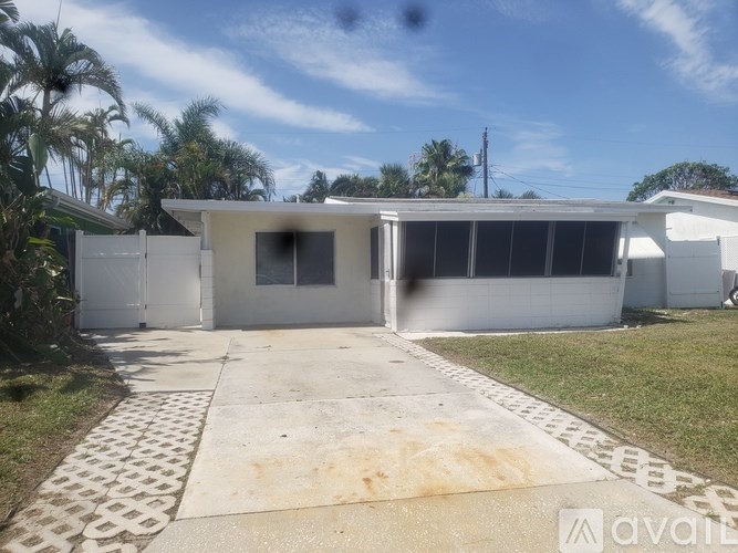 A house with a white exterior and a driveway in front.