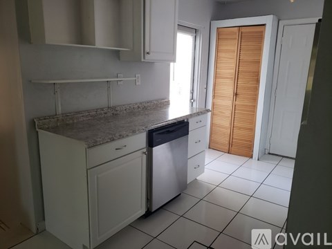 A kitchen with white cabinets and a granite countertop.