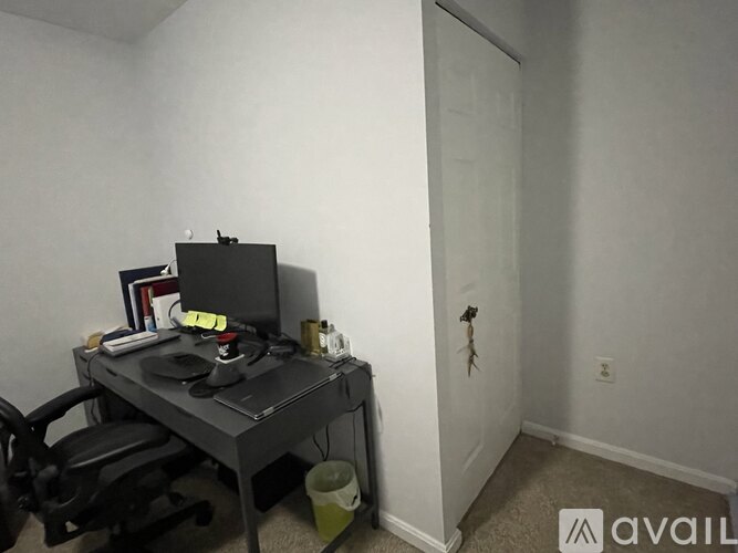 A bedroom with a bed, desk, chair, and lamp.