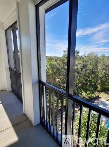 A balcony with a view of trees and sky.