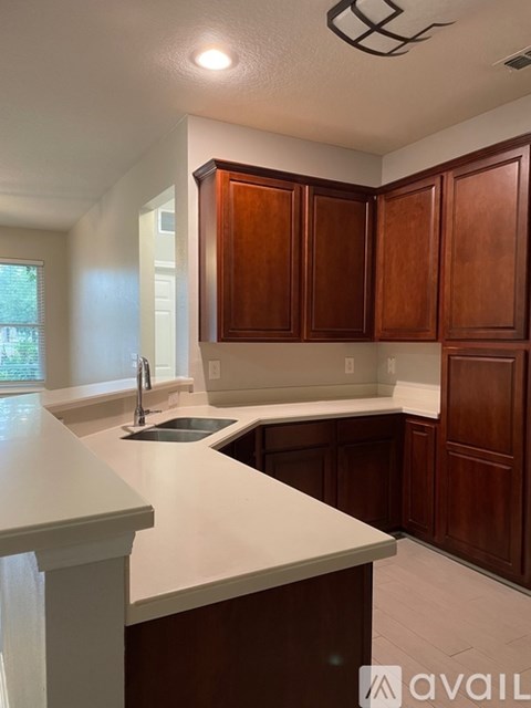 A kitchen with brown cabinets and a white countertop.