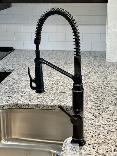 A kitchen sink with a black faucet.