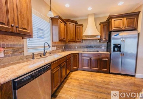 A kitchen with wooden cabinets and a marble countertop.