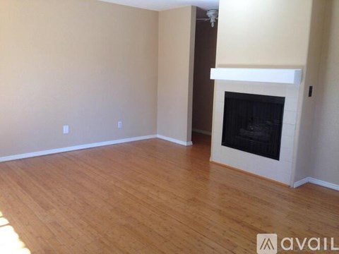A living room with a fireplace and wooden floors.