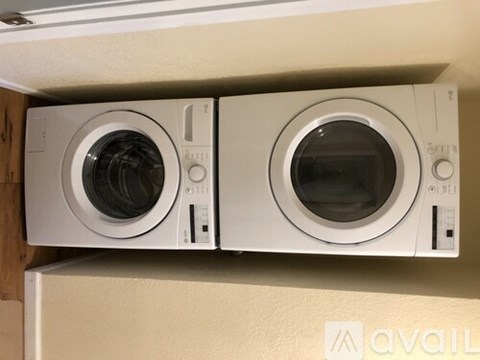 Two front loading washing machines are stacked on top of each other.