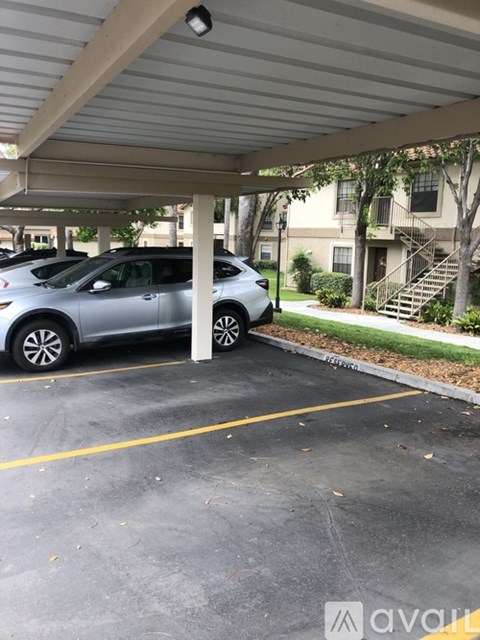 A grey car is parked in a parking lot.