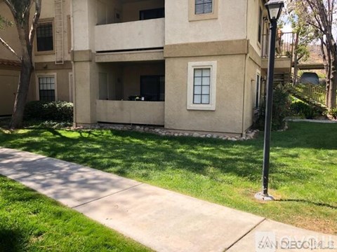 A building with a balcony and a lamp post on a sunny day.