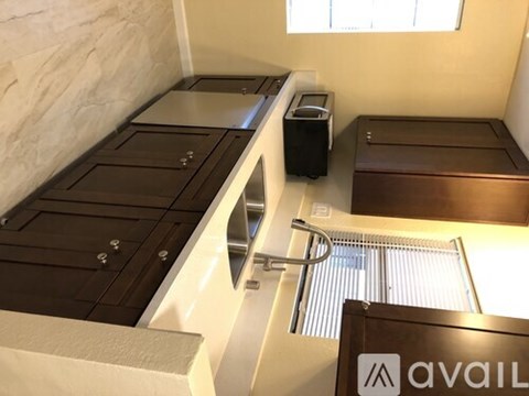 A room with a bed, a sink, and a window.