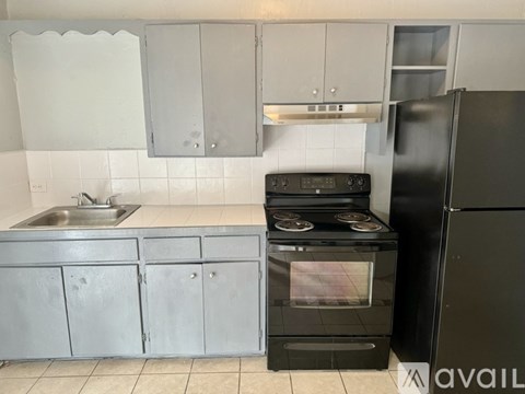 A kitchen with a black oven and refrigerator.
