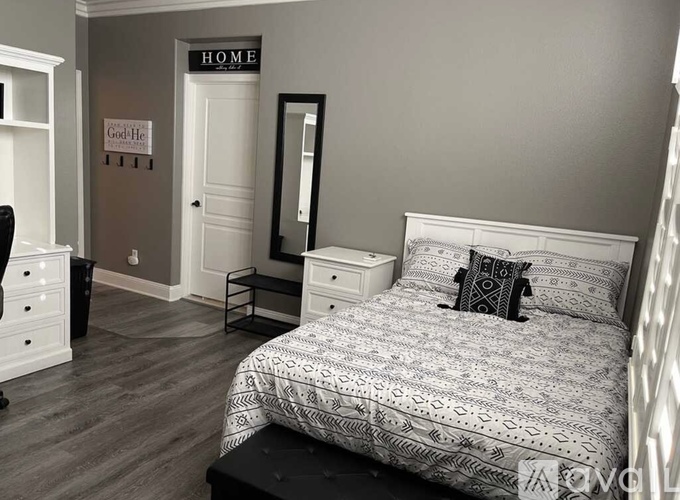 A bedroom with a bed, nightstand, and a dresser.