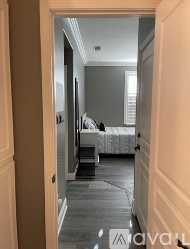 A bedroom with a bed and a mirror on the wall.