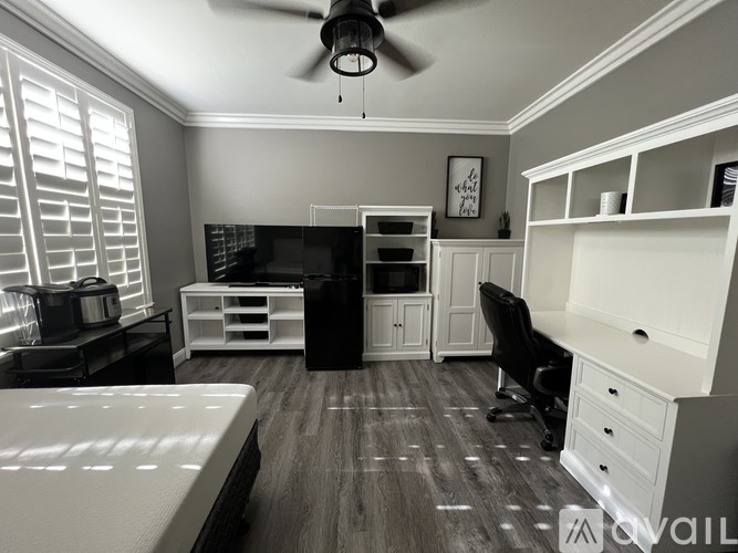 A room with a bed, desk, and chair.