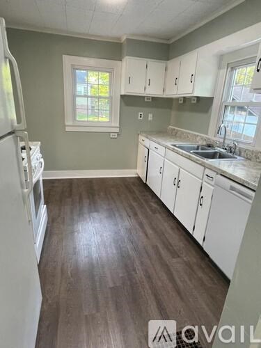 A kitchen with white cabinets and a white fridge.