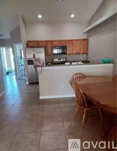 A kitchen with a table and chairs in front of it.