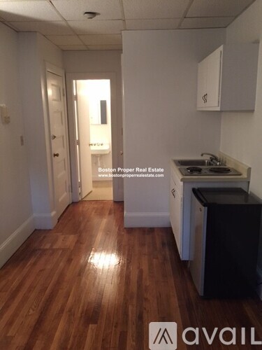 A kitchen area with wooden floors and white walls.