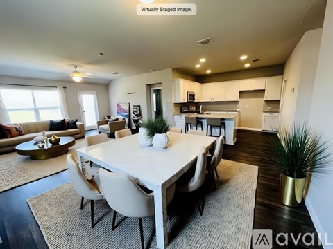 A modern dining room with a white table and chairs.