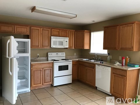 A kitchen with white appliances and wooden cabinets.