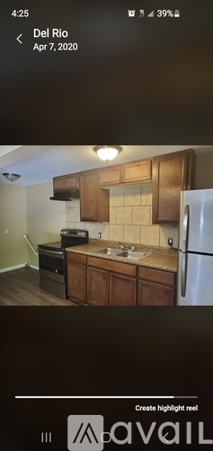 A kitchen with wooden cabinets and a stainless steel refrigerator.
