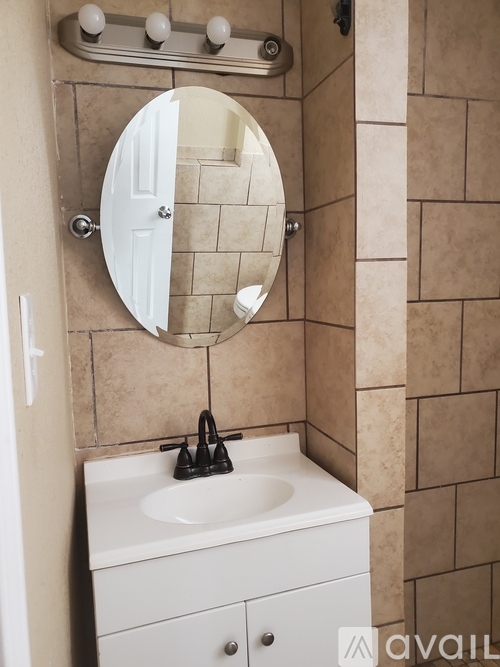 A bathroom with a sink, mirror, and light switch.