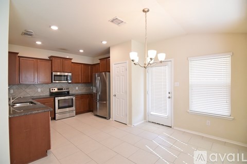 A kitchen with brown cabinets and a white refrigerator.