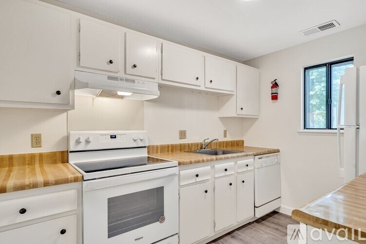 A kitchen with white appliances and cabinets.