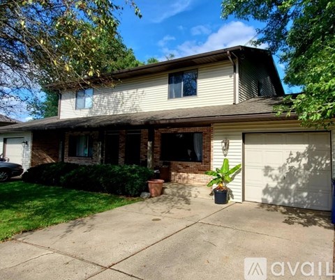 A house with a white garage door and a brown roof.