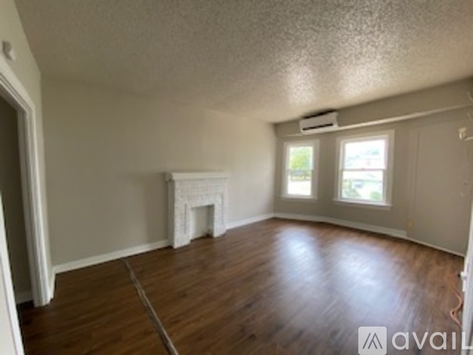 A room with a fireplace and wood flooring.