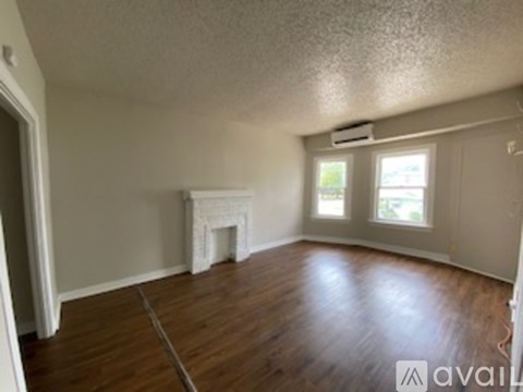 A room with a fireplace and wood flooring.