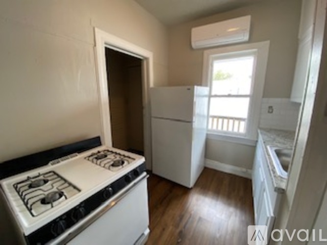 A kitchen with a white stove top oven and a window.