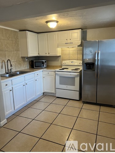 A kitchen with white cabinets and appliances.