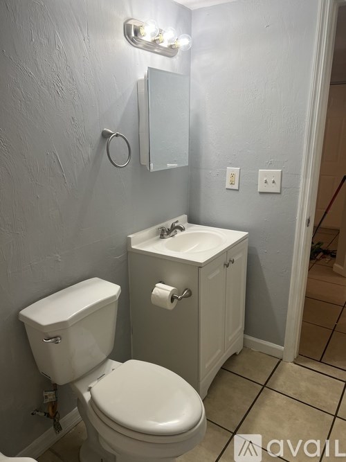 A white toilet and sink in a bathroom.