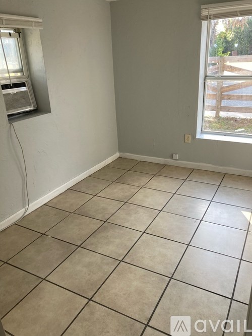 A room with a window and tiled floor.