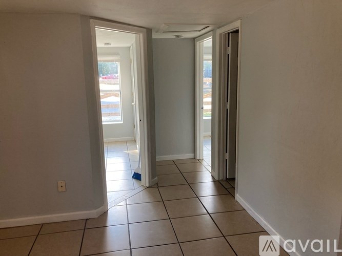 A hallway with tiled floors and white walls.