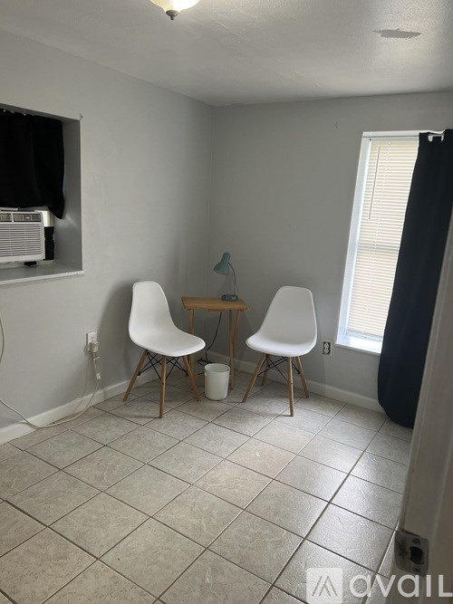 A small dining area with a table and two chairs.