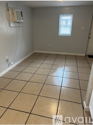 A room with a window and tiled floor.