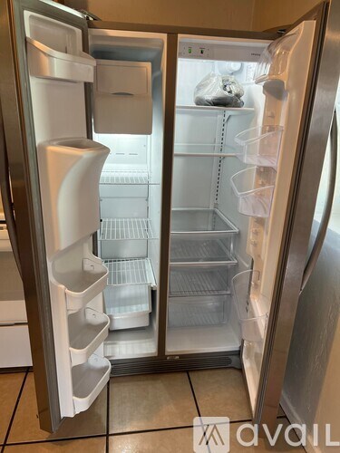 A stainless steel refrigerator with the door open and shelves inside.