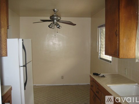 A kitchen with a white refrigerator and wooden cabinets.