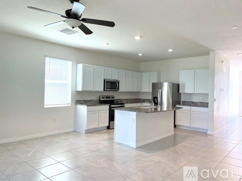 A kitchen with white cabinets and a stainless steel island.