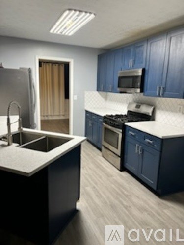 A kitchen with blue cabinets and a white countertop.