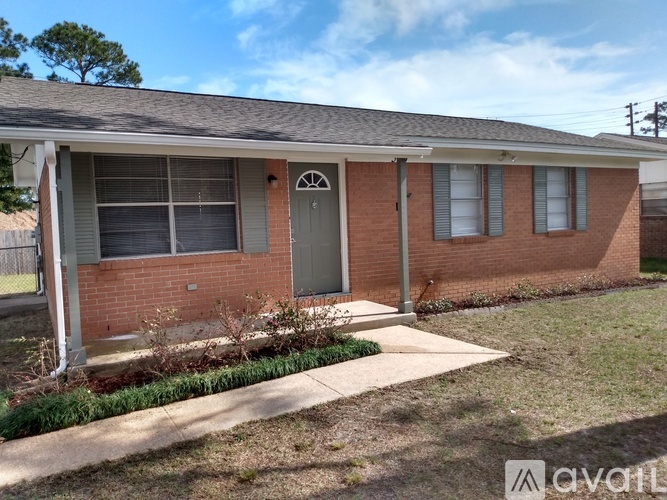 A brick house with a grey door and a small porch.