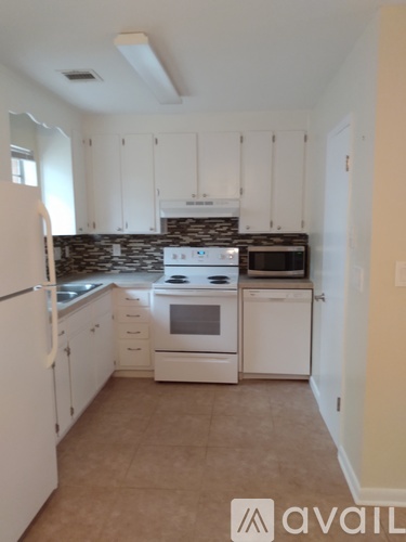 A kitchen with white cabinets and appliances.