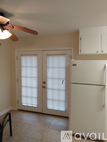 A kitchen with a white fridge and a ceiling fan.