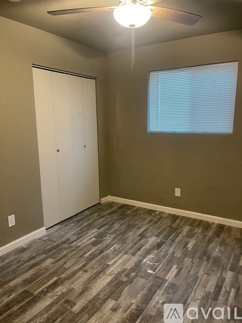 A room with a wooden floor and a ceiling fan.