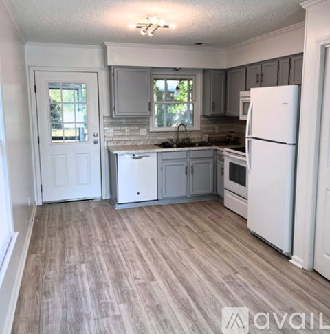 A kitchen with white appliances and wooden floors.