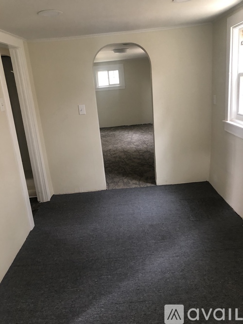 A room with a carpeted floor and a window.