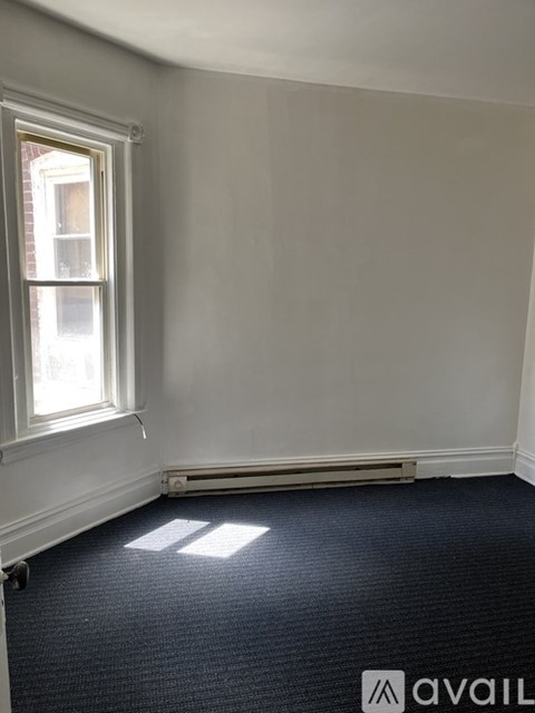 A room with a window and a radiator on the wall.
